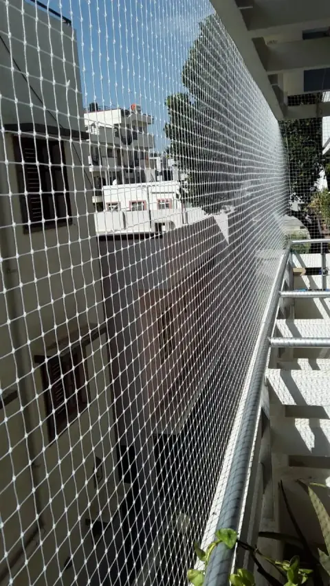 A narrow balcony fully enclosed with a children safety net down its whole length