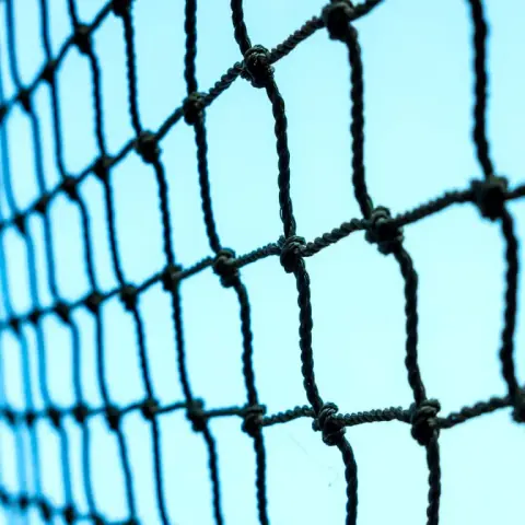 Close-up of heavy knotted cricket net mesh against the sky