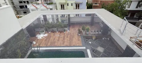 An open area net covering an open courtyard and pool area from wall to wall
